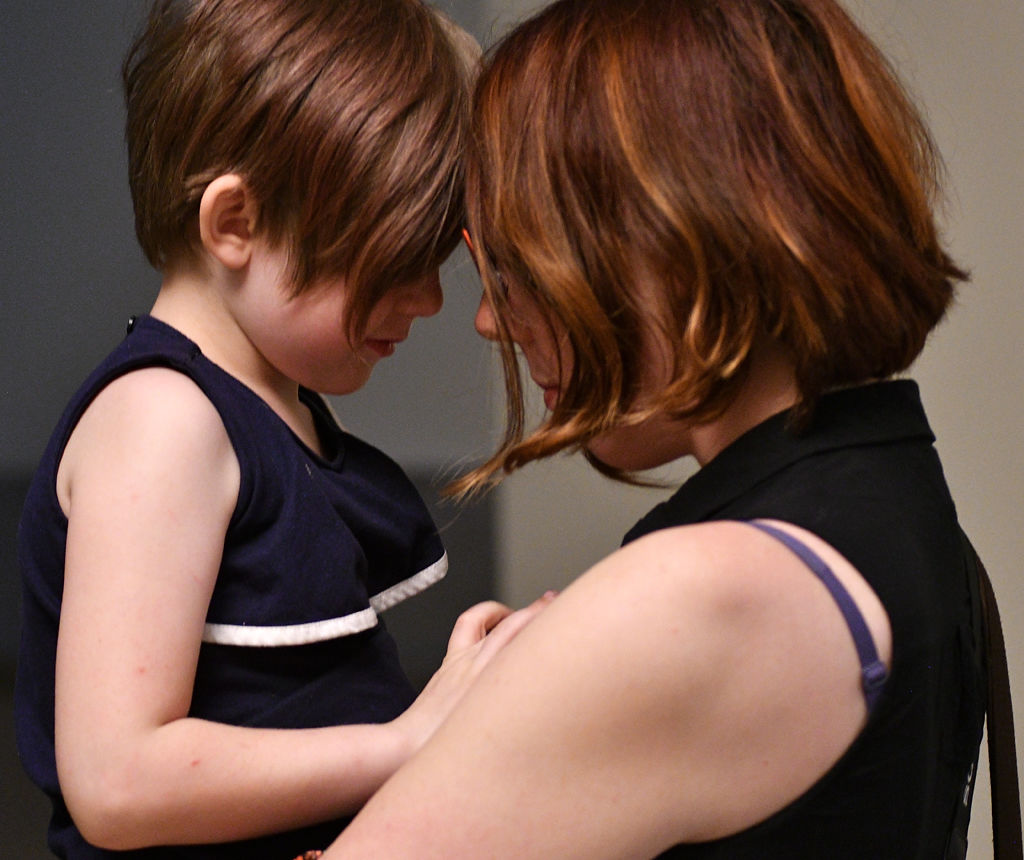 Charlotte Monroe, 5, and her mother Renee Brochu embrace in state Capitol